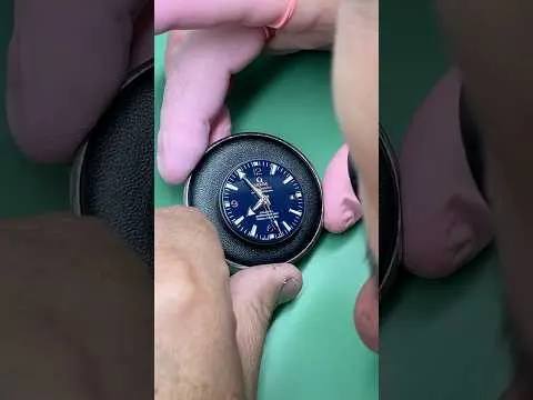 Hands holding an Omega Seamaster during crystal replacement